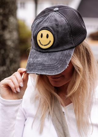 Yellow smiley face trucker hat with black mesh back.