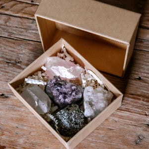 A box filled with sparkling crystals placed on a wooden table.