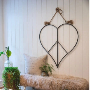 A wall hanging featuring a peace sign and a bench, creating a serene and harmonious atmosphere.