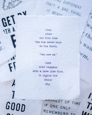 A stack of paper with a beautifully written poem on top, showcasing the artistry of words.