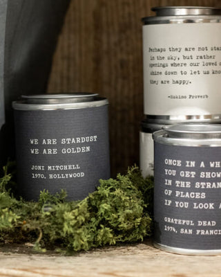 Three tins of candles featuring inspirational quotes.