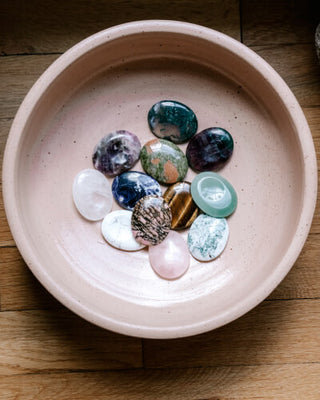 A bowl filled with various stones, creating a captivating display of different shapes, sizes, and colors.