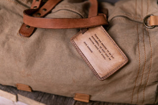 luggage tag hanging on the handle of a duffle bag