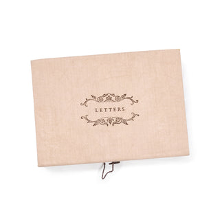 outside of the blush colored stationary box with emblem that says "letters"