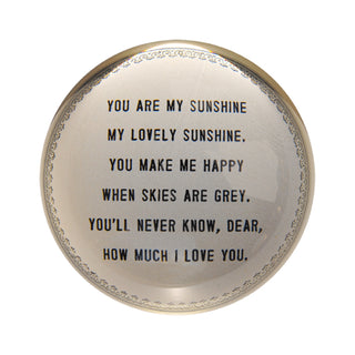 round paperweights with a dark cream backing and black writing